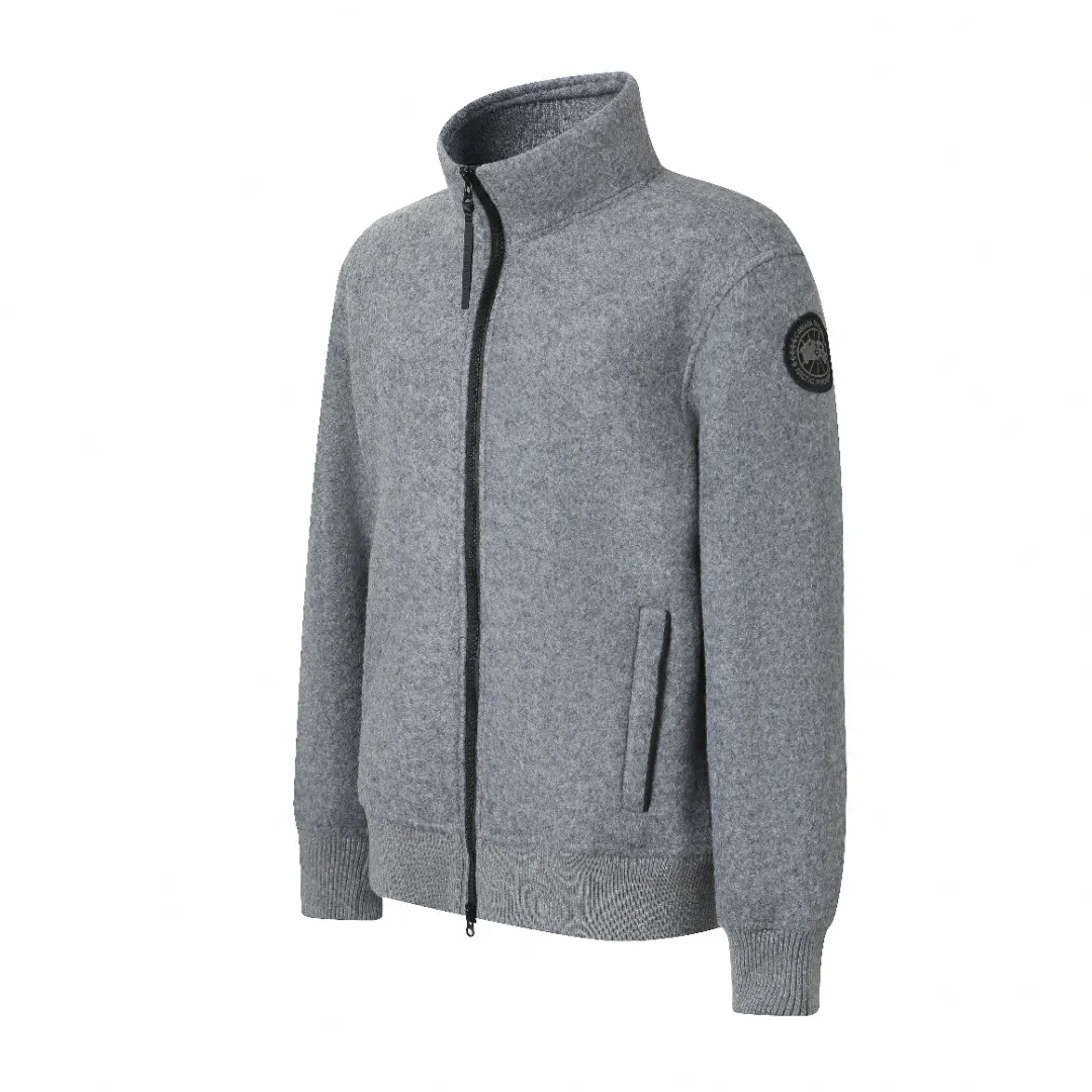 Canada Goose Fleece Badge Stand Collar Jacket Fabric Selection: Wool fleece fabric blended with wool as the main body and a very small amount of spandex and polyester fibers. Wool is a core natural ingredient that provides unparalleled temperature regulation, antibacterial and anti-odor properties and a skin-friendly feel. The feeding of a small amount of spandex gives the fabric a certain degree of four-way elasticity, making it non-restrictive during daily activities. As the basis of fleece's structure, polyester fiber enhances the fabric's durability, wrinkle resistance and quick-drying properties. It contributes to the loft of the fleece and provides functions such as trapping air. Details: The sleeves and hem are closed with 2×2 ribbing. Its strong elasticity can closely fit wrists and waists of different thicknesses, forming an effective 'seal' to prevent cold wind from blowing back. It can still maintain its original shape after repeated stretching and use, and is not easy to loose and deform. And the ribbed cuffs can convey a sense of design and enhance the visual beauty. Production process: The cutting process needs to ensure that the texture and color of the fabric are evenly distributed, especially for this Light Gray tone, color difference needs to be avoided. The stretchability of wool-blend fabrics needs to be taken into consideration when cutting pieces to ensure dimensional stability of the finished garment. • Use a sewing needle and thread suitable for wool-blend fabrics to avoid damage to the fabric during sewing. The sewing stitches are even and firm to prevent thread stripping. • The temperature needs to be controlled during ironing to avoid high temperature damage to the fabric while keeping the fabric smooth and crisp. Armband: The circular armband on the left arm is an important part of the brand identity and is finely sewn to ensure it is secure and flat. Accessories: 1:1 customized zipper clock, 1:1 customized pocket snaps, 1:1 customized armband Size: S M L XL Style number: D
